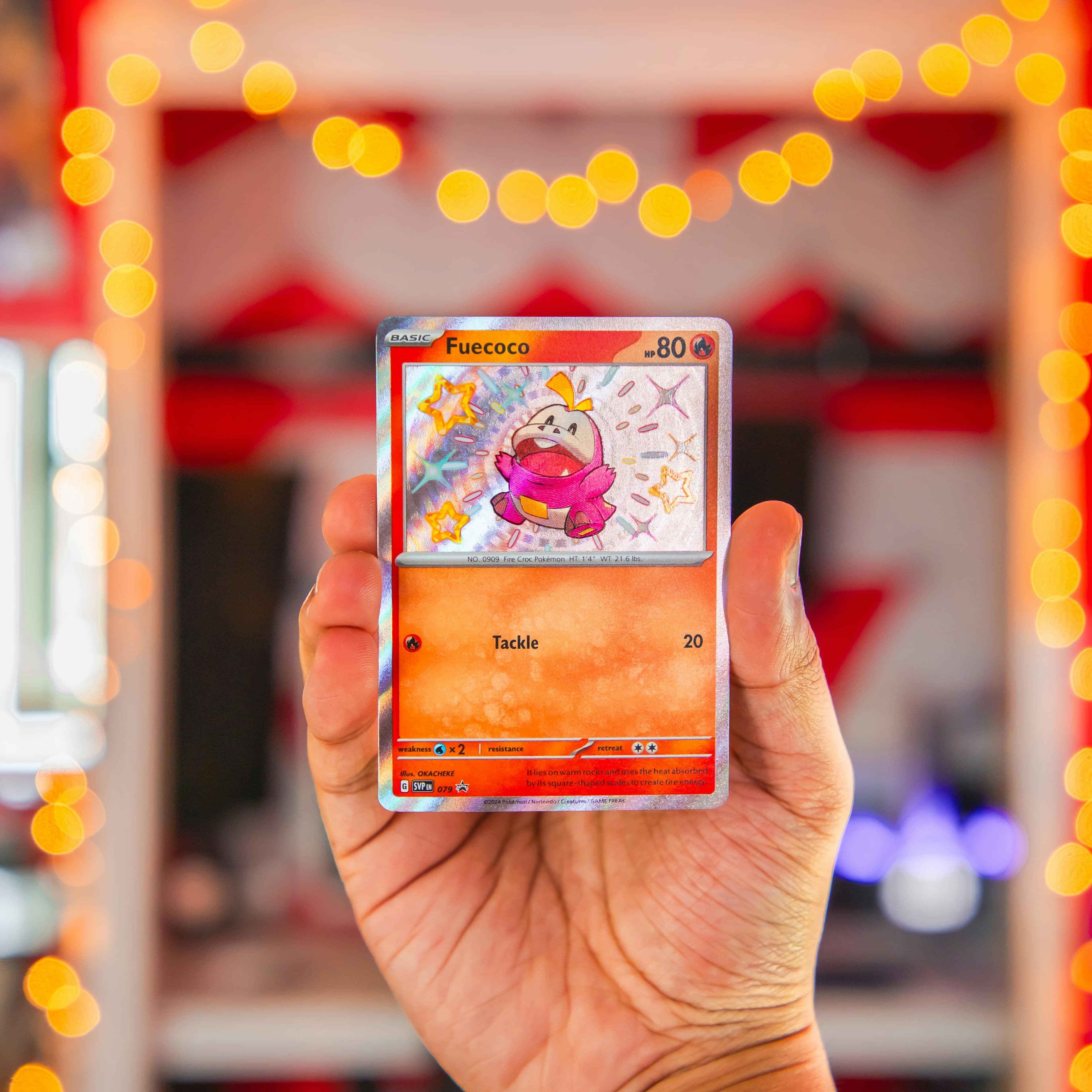A featured Pokemon card held up against warm market lights.